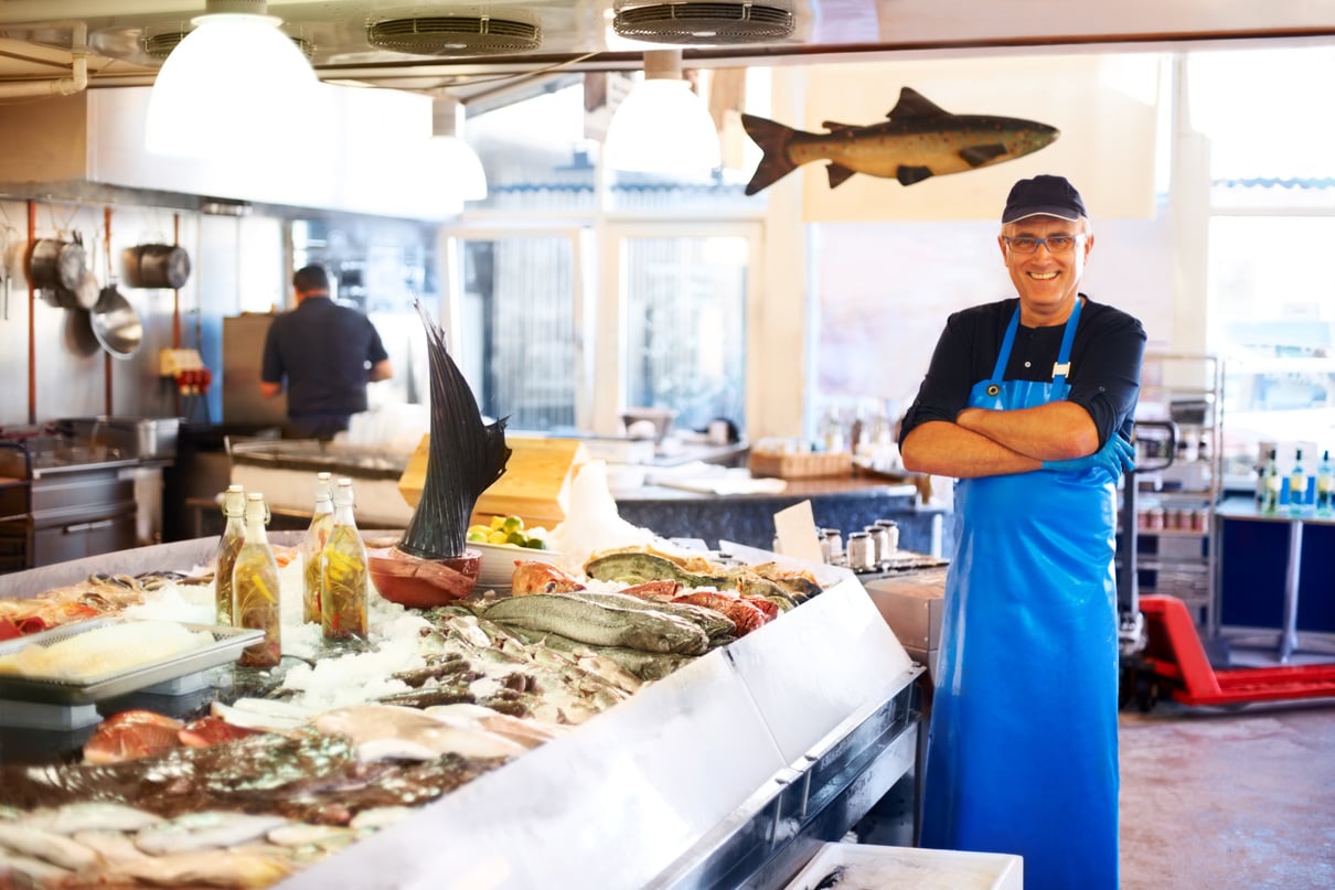 Smiling fishmonger in store